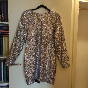 Silvrig paljettklänning från & other stories - Säljer min fina paljettklänning i storlek 36! Rundad halslinning och öppen rygg, paljetterna är silvriga med svart insida. Använd ett fåtal gånger, den är i ett fint skick. Kan mötas upp i Lund, annars står köparen för frakten. ☺️