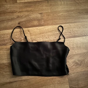 Satin topp  - En svart satin topp från Nakd Annika Tellers kollektion. Den har en dragkedja på sidan, använd endast 1 gång. 