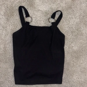 Ribbat linne  - Svart linne med ribbning. Silverringsdetaljer på banden. Aldrig använt