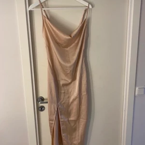 Satin klänning  - En satin klänning i färgen beige. I storlek xs, säljer då jag inte får på mig den. Den har en dragkedja på ryggen och slits vid låret. Säljer för 110kr men priset kan även diskuteras. För mer bilder eller frågor skriv gärna privat.