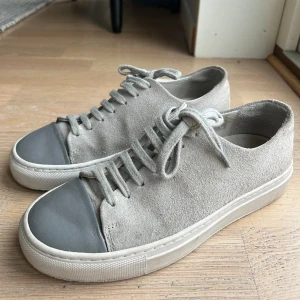 Ljusgrå Axel arigato skor  - Ljusgrå Axel arigato skor i mocka. De säljs inte längre och nypris ligger runt 2000kr. Sparsamt annvända och i mycket bra skick! Skriv privat vid frågor