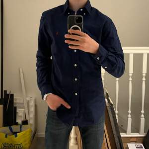 Slim Fit Garment Dyed Oxford Shirt Navy Marinblå skjorta i storleken S, nyskick och inga tecken på användning! Finns på Care of carl för 1400kr