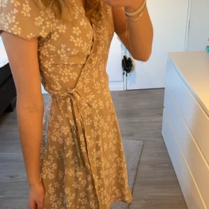 Blommig beige klännign - Fin klänning, knappt använd. 