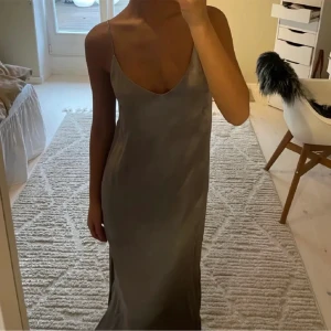 Lång sidenklänning  - Köpt här på plick men för liten därav säljer jag den, bilder från förra ägare, fint skick. Finns fler bilder på mig själv! V-ringad fram, så kallad ”vanlig bak”, har även en slits på vänster sida.