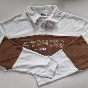 En croppad, tunn långärmad tröja med krage. Köpt på H&M. Storlek S. Beige/brun.