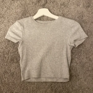  T-shirt  - Hej! Säljer denna gråa tajta t-shirt den på grund av att du inte kommer till användning fint skick oanvänd!