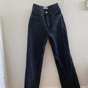 Ett par svarta vida högmidjade jeans i storlek 32. De är i fint skick och har använts några gånger. Jag är 161cm lång och jeansen går ner till mina fötter Säljer för att jag inte använder de längre 