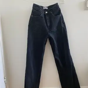 Ett par svarta vida högmidjade jeans i storlek 32. De är i fint skick och har använts några gånger. Jag är 161cm lång och jeansen går ner till mina fötter Säljer för att jag inte använder de längre 