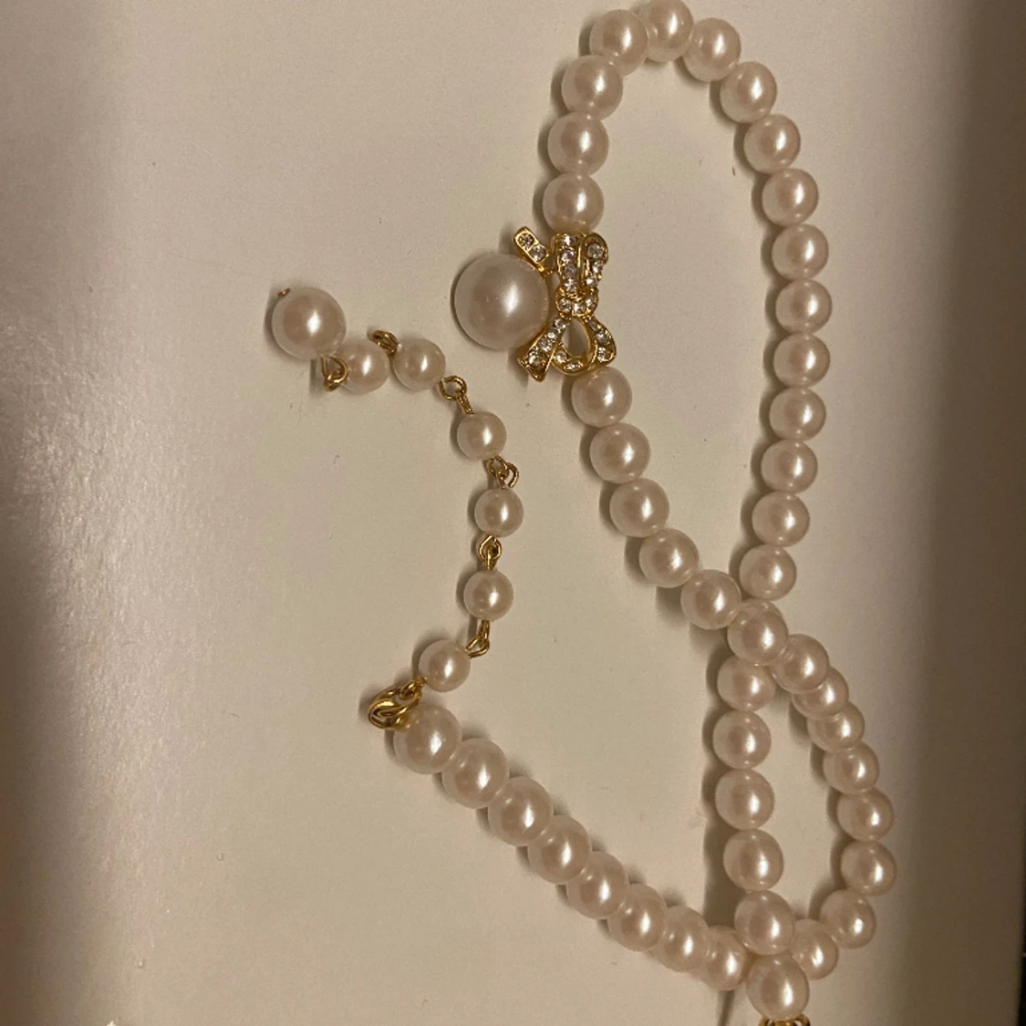 Jättevackert pärlhalsband med rosett