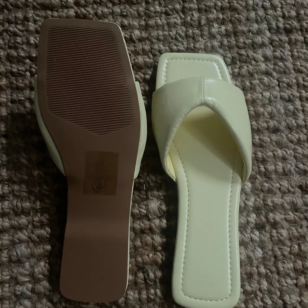 Säljer ett par snygga ljusgula sandaler med fyrkantig tå. har en enkel men stilren design. Perfekta för sommaren och passar till både vardag och fest. De är i nyskick och har en normal passform.. Kengät.