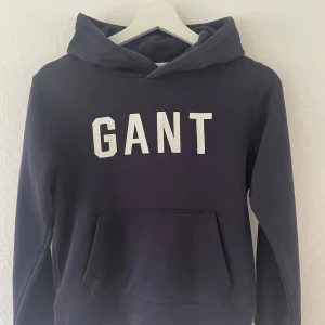 Hoodie från Gant, strl 146/152 - Mörkblå hoodie från Gant. Använt men bra skick. Strl 11-12 years, motsvarar 146/152.