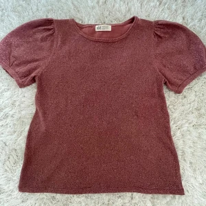 Glittertopp med puffärmar - Supersöt glitter topp med puffärmar!! Ursprungligen från hm o är använd några gånger. Bra skick o inga defekter. Toppen är i storlek 158/164 men sitter precis som S 💞