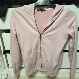 Ralph lauren  - En jätte fin zip tröja från larph lauren. Med en jätte fin rosa färg, tyvärr finns det är en liten orange/gul fläck Använd fåtal gånher