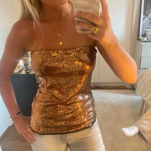 Guldig paljett tubtopp - Tubtopp med guldiga paljetter på framsidan, passar perfekt som festtopp. Storlek L men passar mig som alltid har s i toppar💕💕