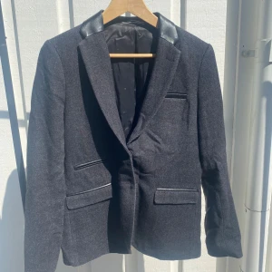 Kavaj/ kavaj-jacka - Snygg kavaj/ jacka med skinndetaljer från J.Lindeberg i bra skick! Färg: mörkgrå/svart