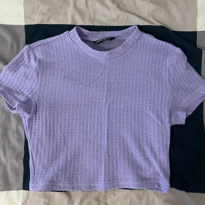 Lila ribbad topp från SHEIN - Säljer en superfin lila ribbad topp från SHEIN. Den är i storlek XS och har korta ärmar. Perfekt för både vardag och fest! 💜