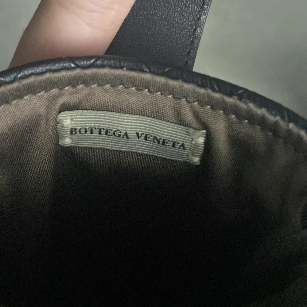 Säljer en elegant svart quiltad plånbok från Bottega Veneta. Plånboken har ett stilrent rutmönster och en praktisk stängning med en flik. Perfekt för att hålla dina kort och kontanter säkra. Passar både till vardags och fest!. Väskor.