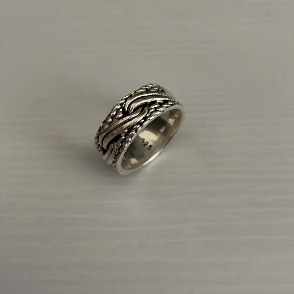 En silverring med ett detaljerat flätat mönster. Köptes i Tyskland för 3 år sedan för runt 85 euro (850kr). Gjord på 925 silver, vilket innebär att 92.5% procent är ren silver. Används inte längre men är riktigt snygg o passar nästan allt. Skriv för mer information 😁. Asusteet.