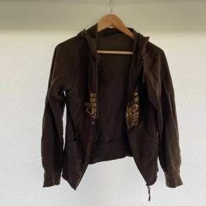 Brun kofta Vero Moda - En brun kofta från Vero Moda med dragkedja och tryck på framsidan. Använd 1 gång. Storlek: M. Hör av er vid eventuella frågor!!