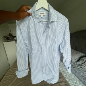Randig skjorta - Säljer denna randiga blå vit randiga skjorta med tunna ränder och snygg textur. Använd en gång. 10/10 kvalitet, och väldigt bra material. Priset är inte skrivet i sten. Så bara att höra av sig vid minsta lilla fundering🤝