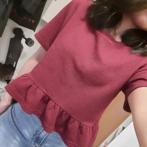 Tröja med volang - Fin vinröd tröja med volang nertill.