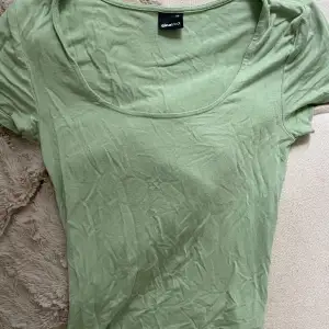 Jätteskön ljusgrön tajt t-shirt från Ginatricot i storlek Xs. Använd 2-3 gånger.