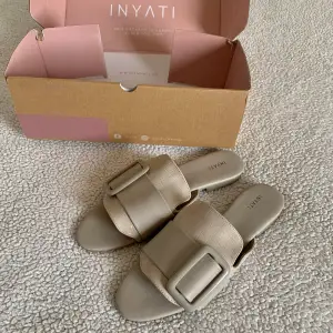Supersnygga sandaler från Inyati. Aldrig använda, i nyskick utan anmärkningar. Ofdinariepris 65 EUR. Färgen är typ beige/grå. 