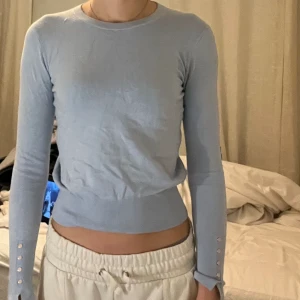 Finstickad tröja från zara - Finstickad blå tröja med guldknappar längst ner på armen. 