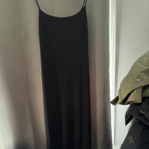Maxiklänning  - Svart maxiklänning från Bik Bok med slits baktill.  Går ner till marken på mig som är 174 cm lång. Tajt passform. 