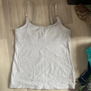 Linne -  Jättegullig grå linne/topp med vita ränder, insydd bh topp på insidan så att man kan gå utan bh. Man kan även justera strapsen. Jätteskönt material💝 Oanvänd! Funkar även jättebra som nattlinne! Säljer också en prickig och svart!