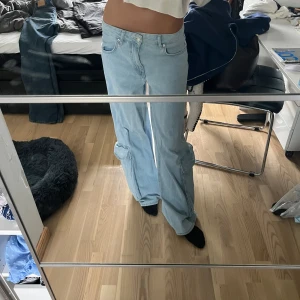 Lågmidjade jeans  - Ett par lågmidjade jeans med cargo fickor. Midjemått 35, innerbenslängd 78