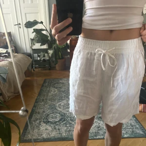 Vita linneshorts  - Vita baggy linne shorts som är perfekta till sommaren. Aldrig använda. Kan vara lite genomskinliga eftersom det är linne material. Köpta på ginatricot med nypris 279kr. Hör av vid intresse🤍
