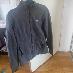 Lacoste Kofta Grå - Grå Lacoste Kofta Säljs ej längre Mycket bra skick och mycket fin Pris kan diskuteras  Passar S och M