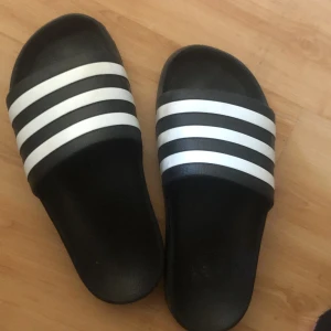 Adidas tofflor  - Bra skick vet inte exact vilken str men den är små och det står 4 i den men skulle gissa på 35 36 37 