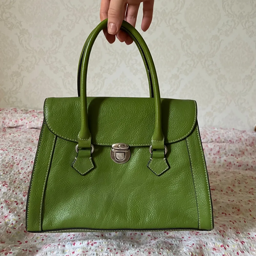 Grön väska köpt second hand i England!💚Den har ett fack med dragkedja och två små andra fack inuti. Har aldrig använt den och väskan är i mycket bra skick! Måtten är 28x20x10. Väskor.