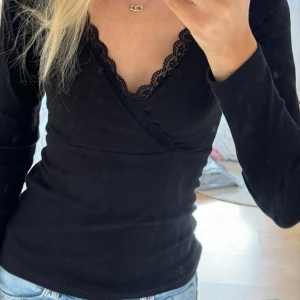 Långärmad tröja med spets  - Säljer denna långärmad tröja med spets och omlott upptill. Använd fåtal gånger så skicket är superbra. Står ingen storlek men är väldigt säker på att det är S.