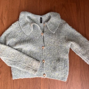 Underbar kofta - Så fin stickad kofta i turkos med guldiga knappar med pärlor. 