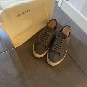 Gråa Axel arigato skor  - Säljer mina arigatos, i suede  Bra skick inga direkta defekter elelr skador men lite spår av användning bara. Allt og medföljer