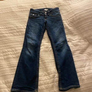  jeans i mörkt blått  - Ett par lågmidjsde jeans som är mörkt blått