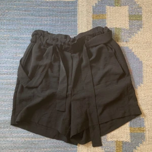 Tyg shorts  - Säljer mina fina svarta tygshorts. Dom är fina och i gott skick, men använda. Ser nästan lite it som en kjol på!