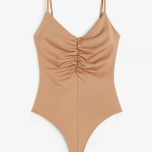 Mörkbeige body - Helt ny mörkbeige stringbody från hm. Jätteskön och ger fina kurvor. Aldrig använd. 