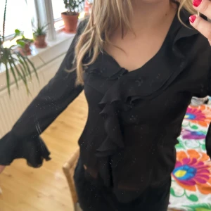 Blus med volanger - Supersöt svart blus med volanger i mesh 