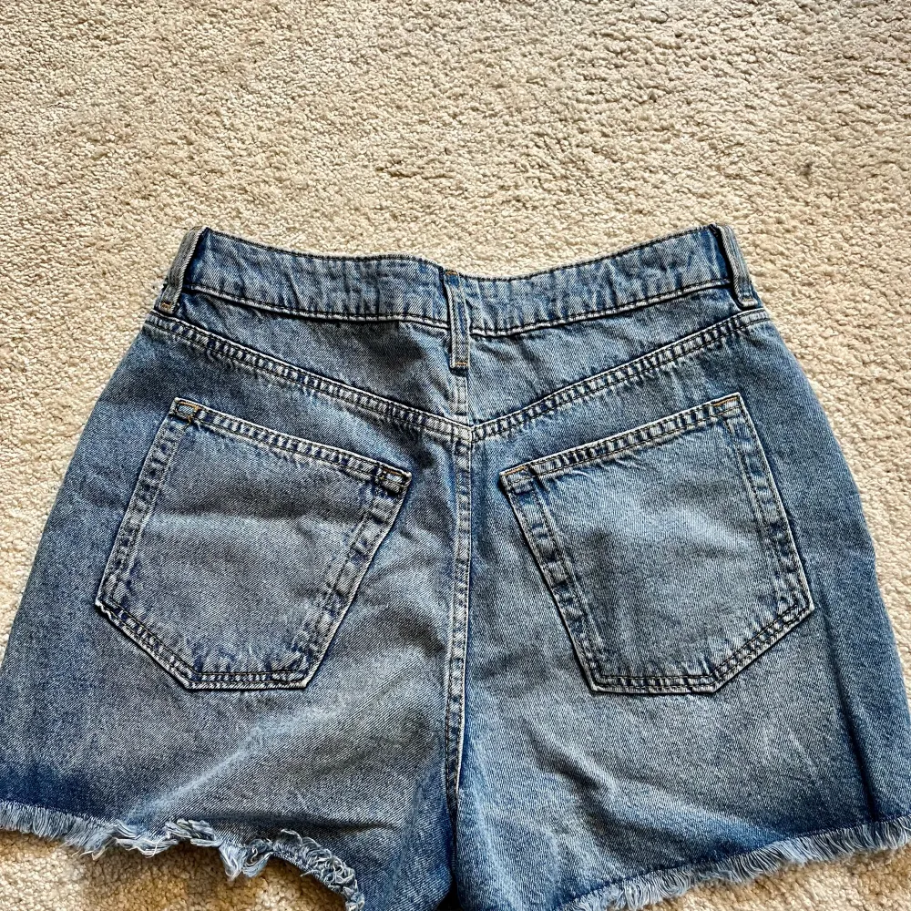 Oanvända jeansshorts med slitningar från HM, storlek M.. Shorts.