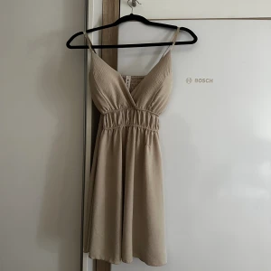 Sommarklänning xs-m - Stretchig beige sommarklänning som passar XS-M  Använd två gånger   Har en sömm som börjat gå upp lite men det syns inte när man har på sig klänningen