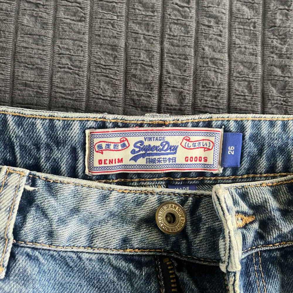 Ett par korta jeansshorts från Superdry. Snygg tvätt med snygga hål där fram. De är använda men i bra skick fortfarande 😉De är i storlek 26 och tyvärr för små för mig, de är anledningen till att jag säljer de. Skriv till mig om ni undrar nåt 🥰. Shorts.