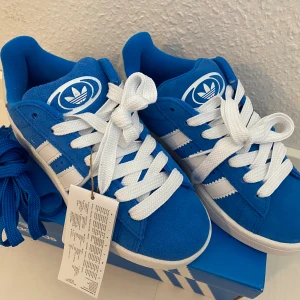 Nya Adidas Campus 00s -storlek 36 2/3 - Adidas Originals Campus 00 s j OBS Storlek: 36 2/3 Färg: Blue Bird / Cloud White / Blue Bird Ingår både blåa och vita skosnören. Nya och oanvända. Ligger kvar i kartong. 