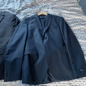 Kavajer + ett par byxor till ena kavajen - Skick-9/10, säljes då de inte passar mig längre. Båda kavajerna är i väldigt fint skick knappt använda. Till den marinblåa kavajen så finns även ett par byxor till den att köpa till.