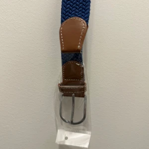 Flätat bälte - Bältet är i mycket bra skick och helt oanvänt det är också riktigt snyggt. Färg på bältet är blått.