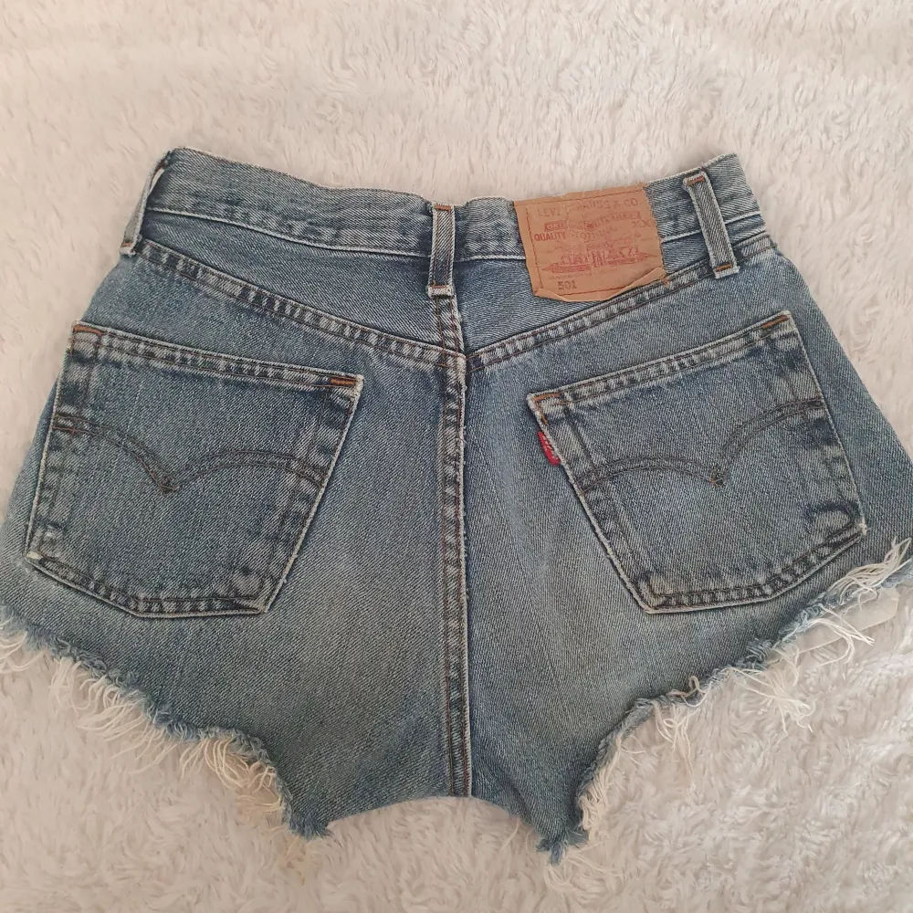 Levi's 501 jättefina blåa jeansshorts köpta på erikshjälpen! Säljer på grund av tyvärr för små 😭💕 står ingen storlek men skulle tro XS, midjemått rakt över är 32 cm!. Shorts.