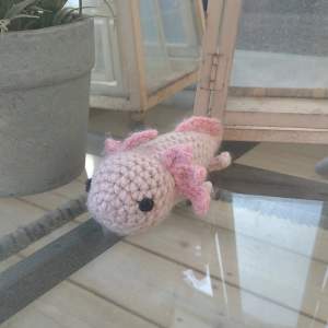 En fin rosa liten virkad axolotl. Handgjord av mig. Vill du ha den i en annan färg (t.ex grå & svart) så får du skicka ett DM på instagram så löser jag det åt dig! Går att köpa via instagram också, finns länkad i bion @ SmyckEmma heter jag där. 